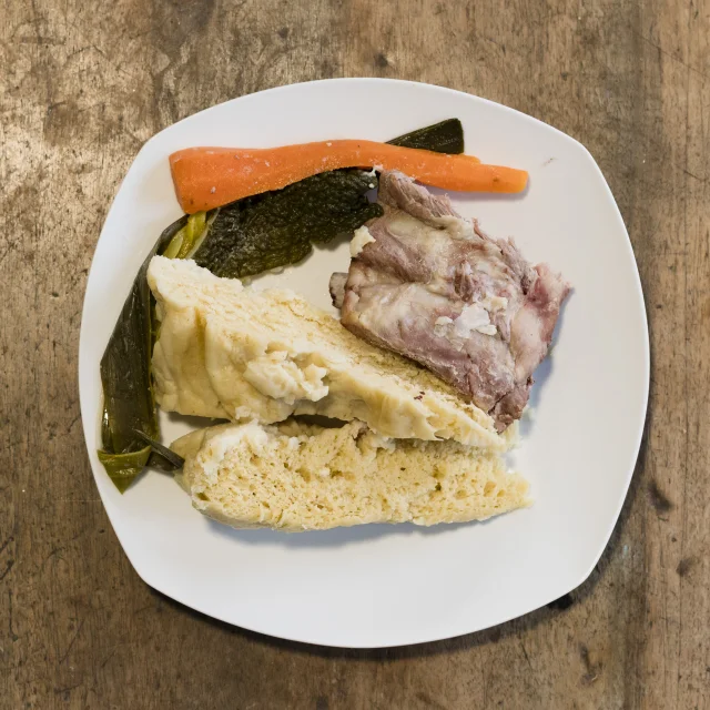 Assiette avec une mique levée, des légumes et du petit salé